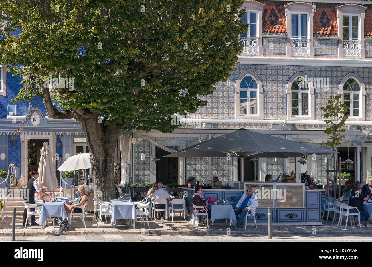 La gente siede ai tavoli all'aperto in un ristorante a Sintra, Portogallo Foto Stock