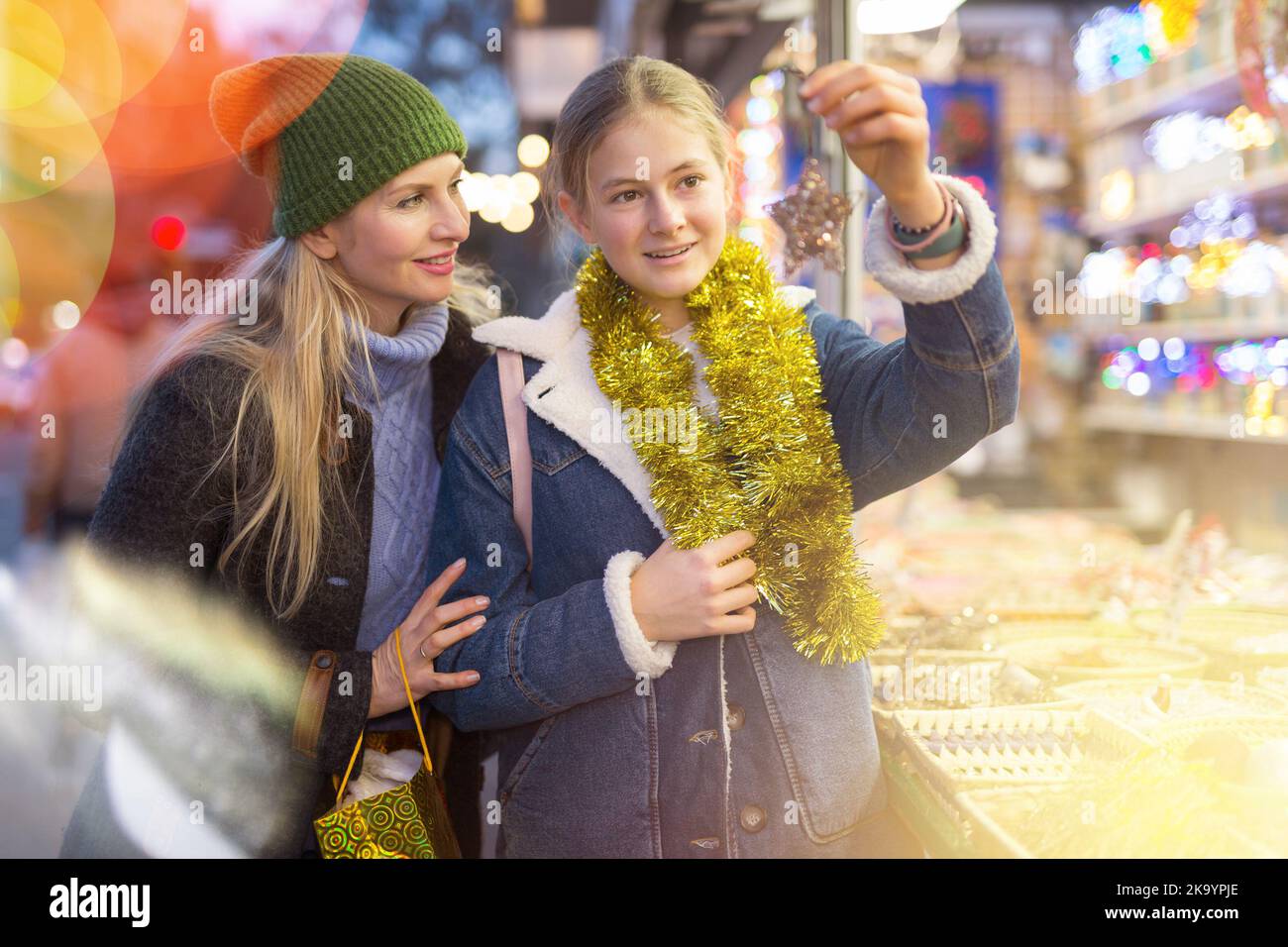 Madre felice con la figlia che sceglie la decorazione di Natale e le palle al mercato di Natale Foto Stock