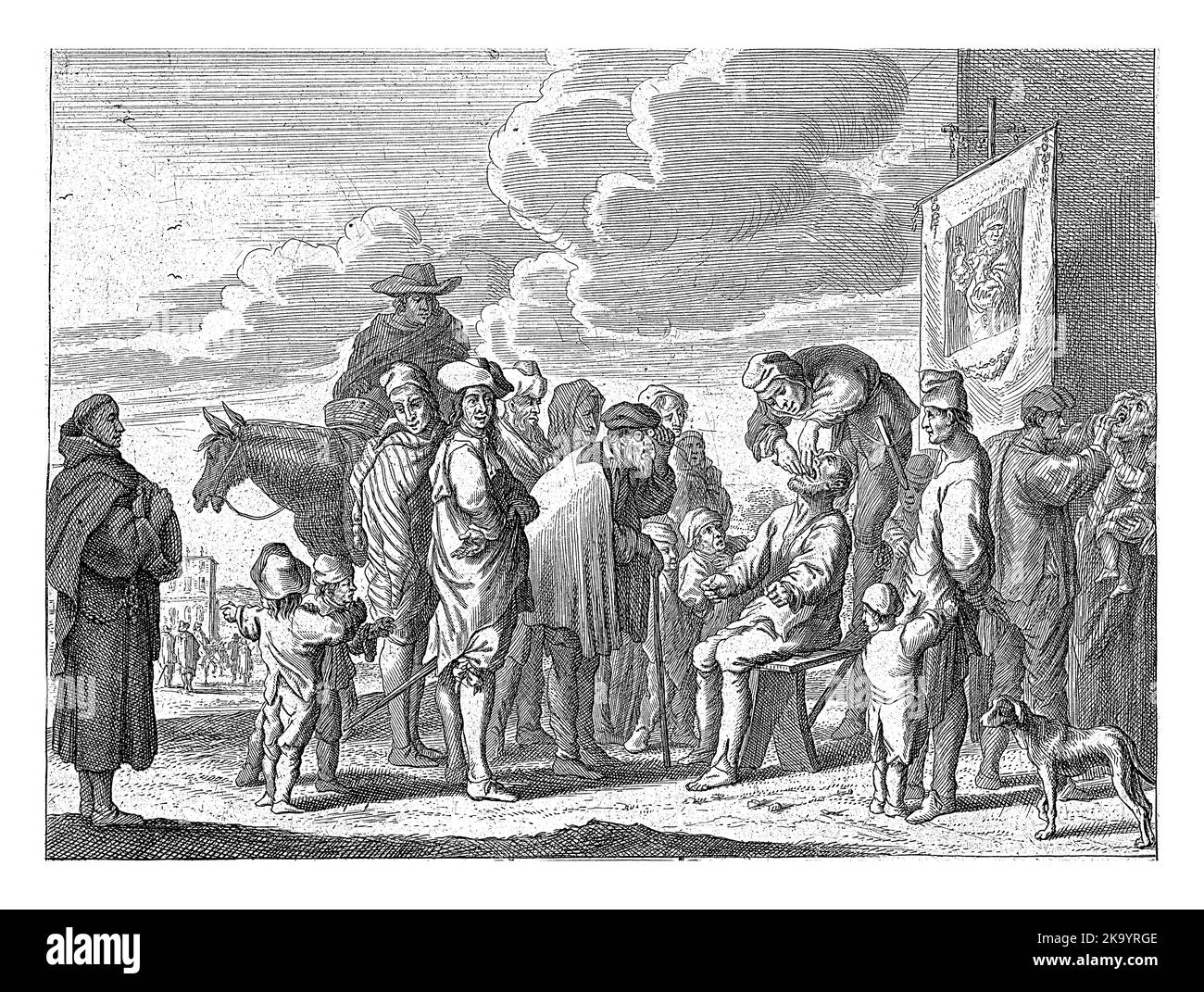 Un sacco guarda nella bocca di un uomo. Un gruppo di persone si è riunito intorno a loro. A sinistra un monaco che guarda. Foto Stock