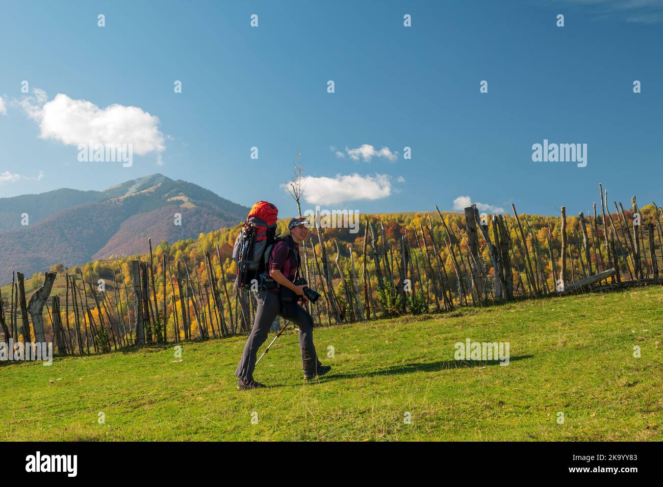 Donna escursionista con zaino va in salita sul percorso di trekking in montagna Foto Stock