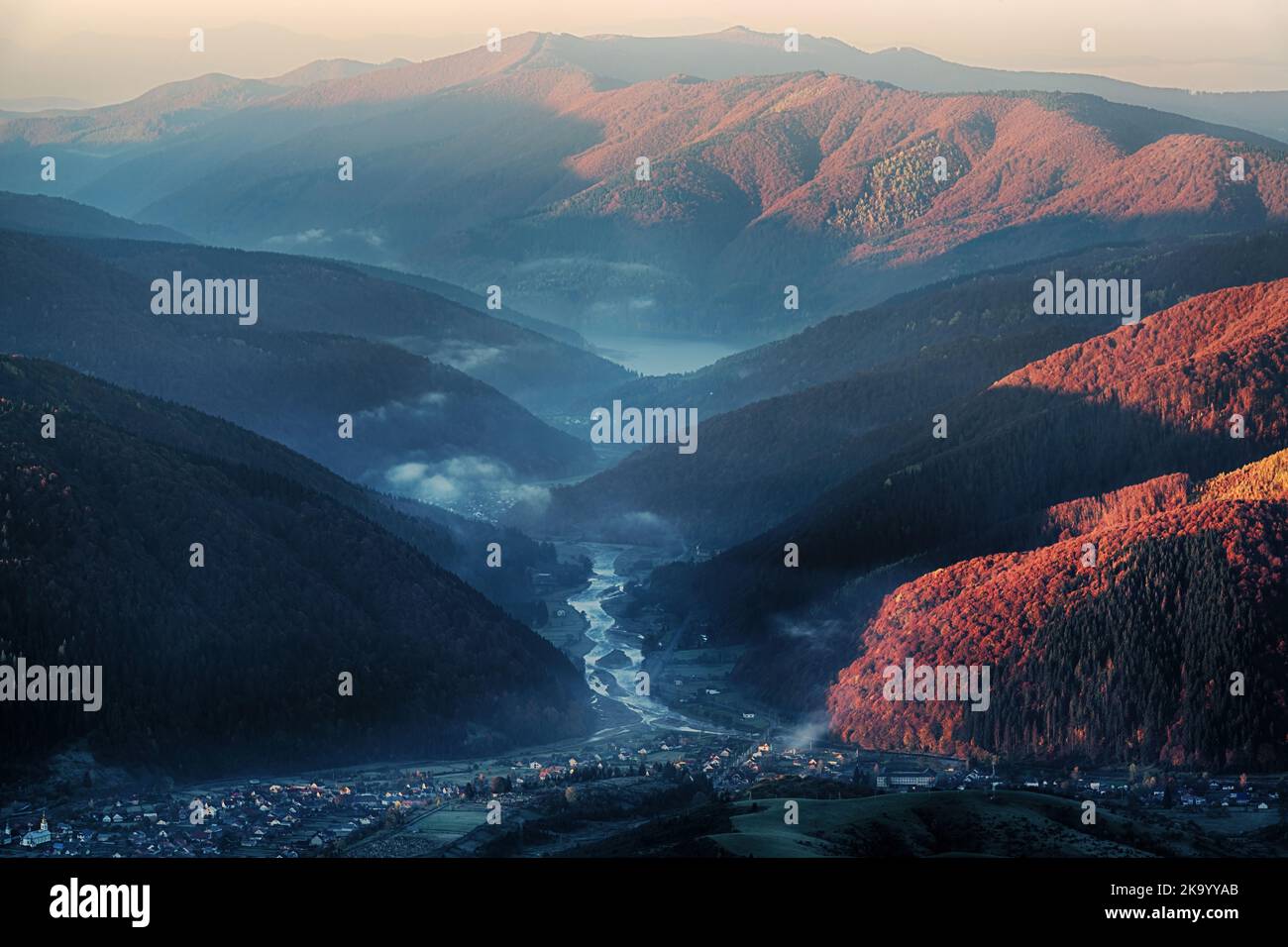 Bella mattina in montagna con valle del fiume, nebbia e abeti luce del sole Foto Stock