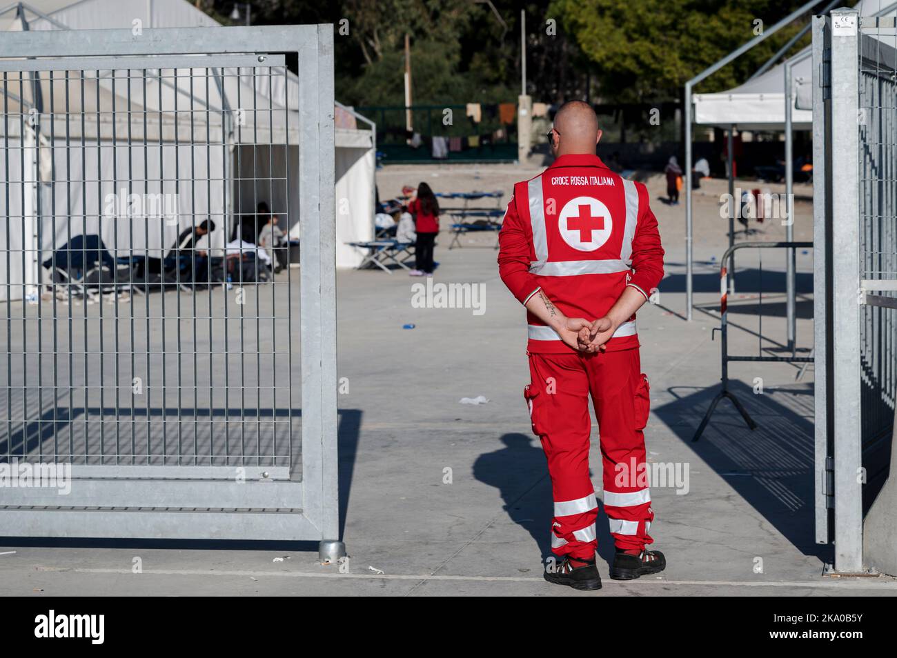 Roccella Jonica, Reggio Calabria, Italia. 30th Ott 2022. Un membro della Croce Rossa visto di fronte al campo. 55 migranti, provenienti principalmente dall'Iran e dall'Afghanistan e provenienti dalla Turchia, erano stati salvati dalla Guardia Costiera Italiana e dalla polizia delle Finanze e portati a Porto delle grazie, il porto di Roccella Jonica, regione Calabria (Italia). Medici senza frontiere, Croce Rossa e protezione civile hanno fornito assistenza all'arrivo. (Credit Image: © Valeria Ferraro/ZUMA Press Wire) Foto Stock