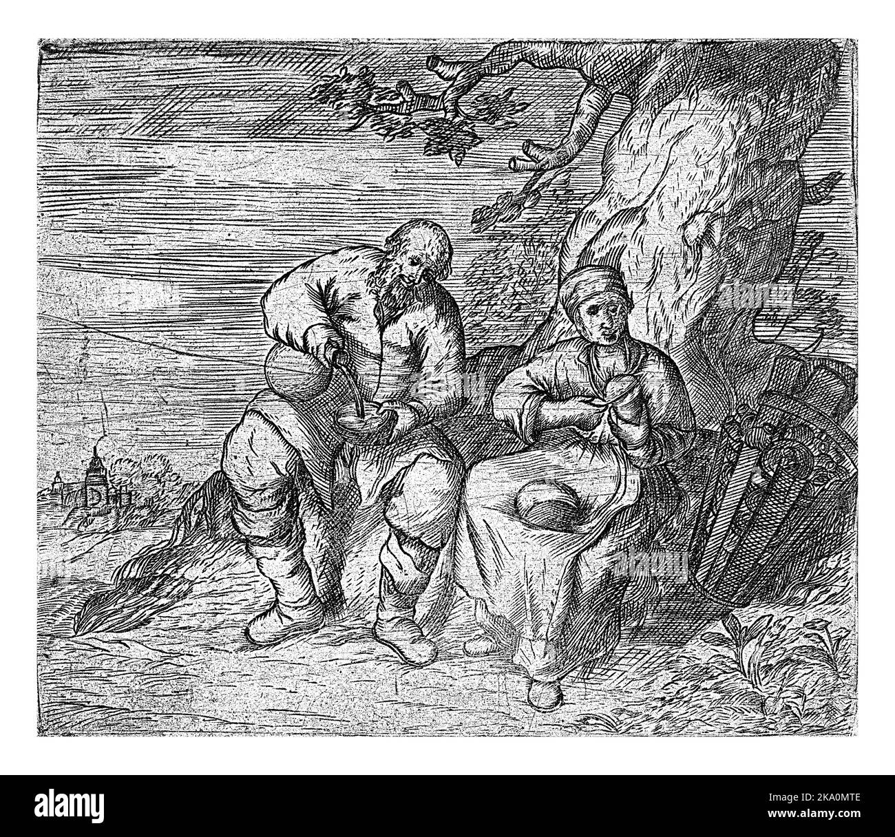 Un uomo e una donna si siedono sotto un albero e mangiano. La donna taglia il pane, l'uomo versa qualcosa da bere in una ciotola. Foto Stock