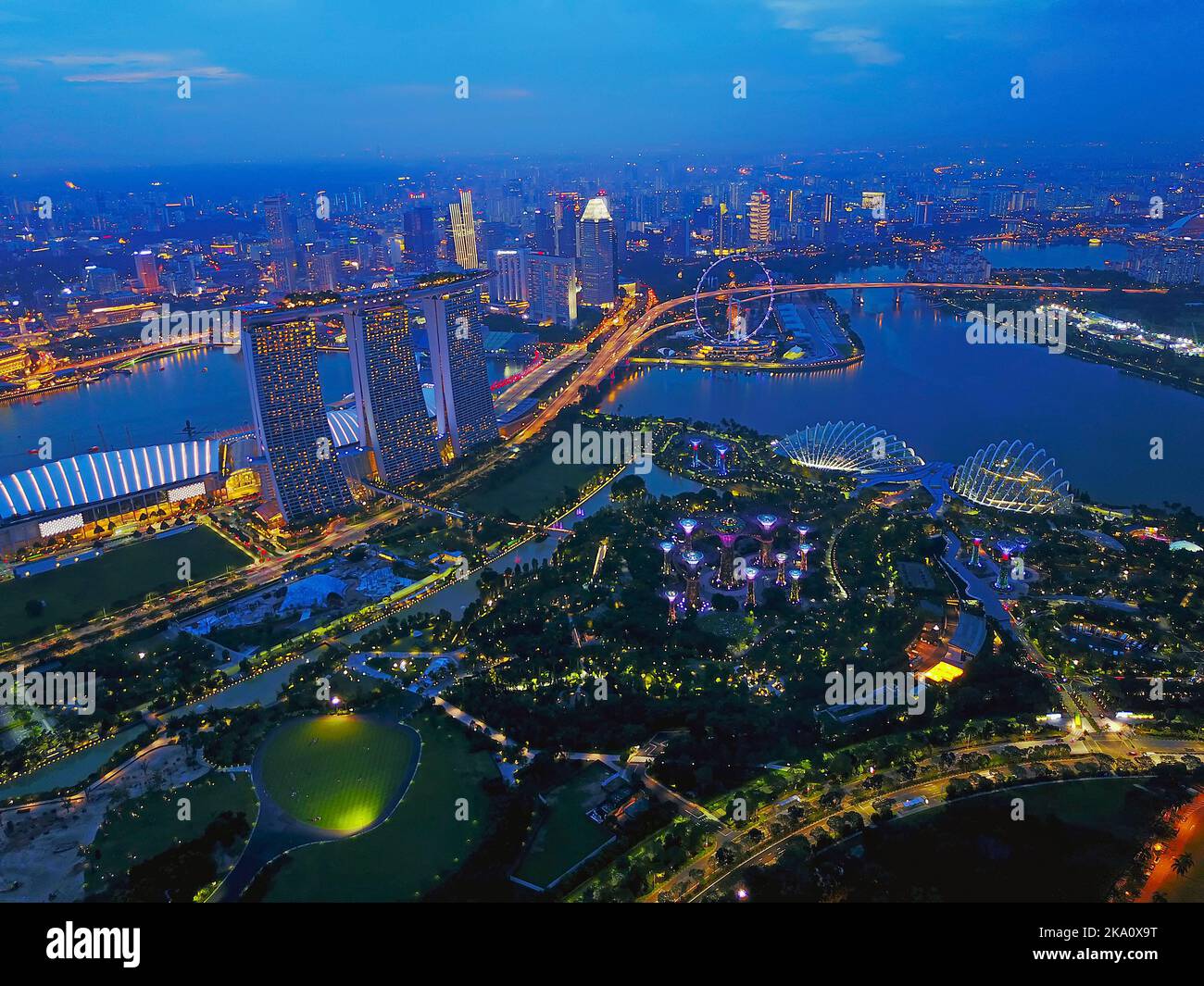 Vista aerea dei grattacieli di Singapore con skyline della città durante il giorno estivo nuvoloso. Leggermente morbido e rumoroso grazie all'elevato livello iso e alla lunga esposizione. Foto Stock