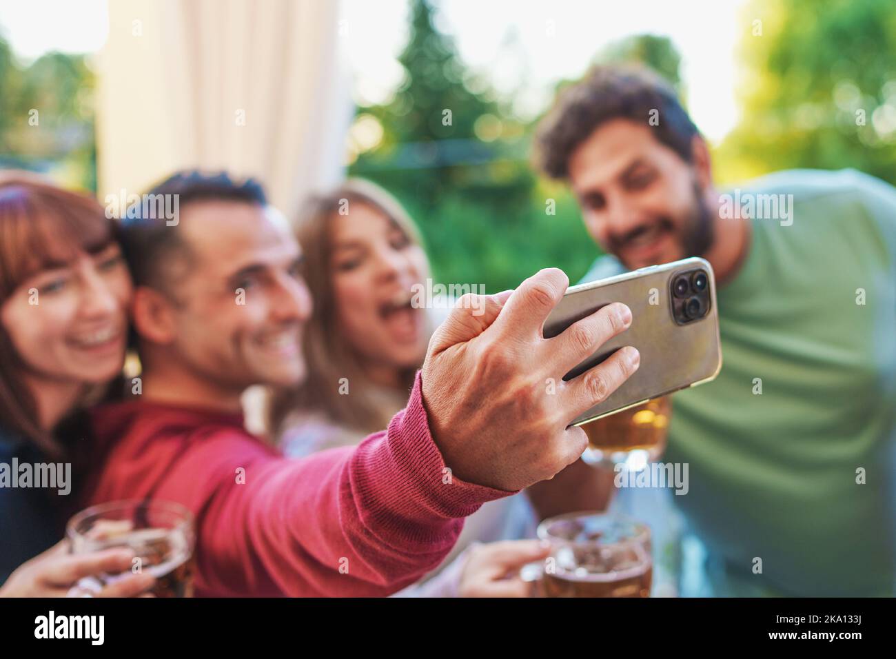 Amici felici alla festa in terrazza che prendono selfie con il loro smartphone divertirsi insieme - giovani millennial che prendono i ricordi all'aperto nel terr Foto Stock