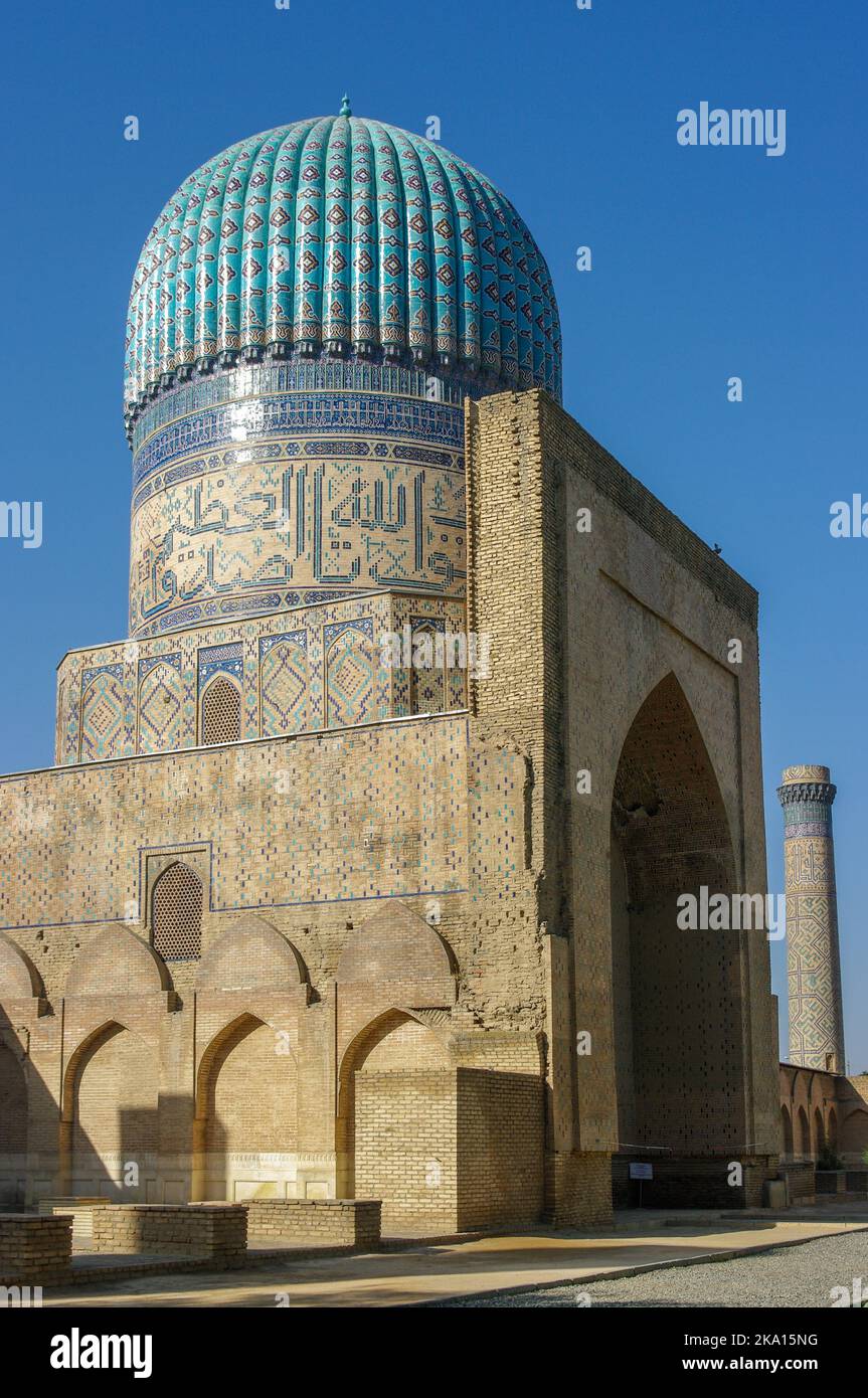 Vista laterale della bellissima antica moschea Bibi Khanum o Bibi Khanym con cupola in piastrelle blu e minareto in Samarcanda, patrimonio dell'umanità dell'UNESCO, Uzbekistan Foto Stock