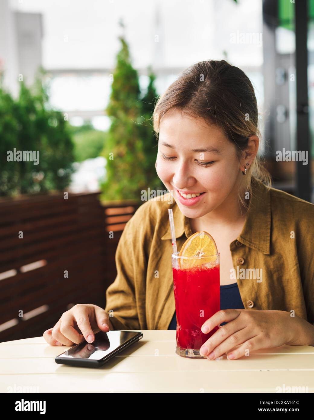 carino ragazza asiatica leggere messaggio con smartphone Foto Stock
