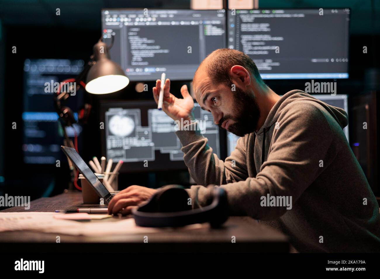 Un programmatore attento che ha pensato a una soluzione di codifica, trovando un algoritmo per creare uno script di database. Senso di penitenza e pensare al sistema di sviluppo del software a tarda notte. Foto Stock