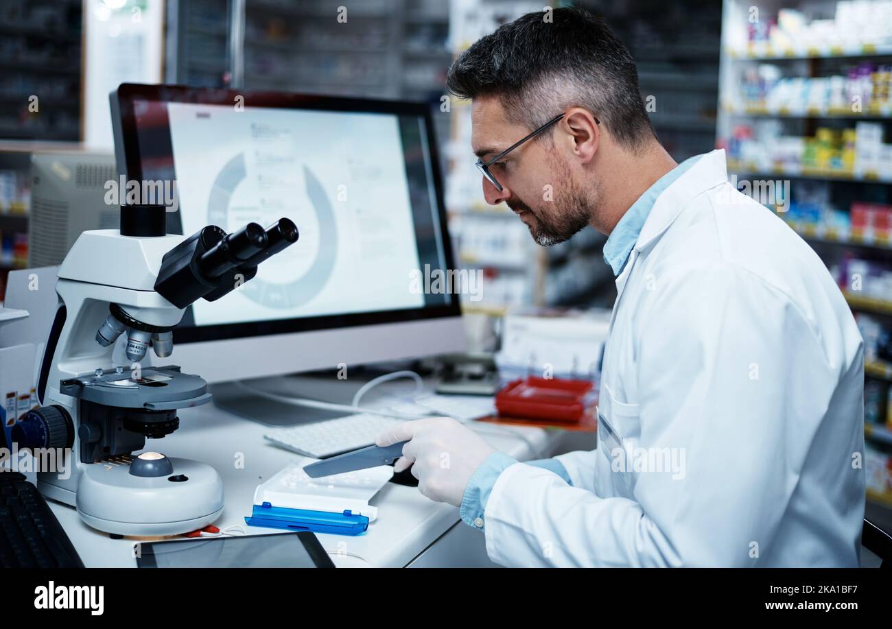 La giusta quantità per il vostro trattamento. Un farmacista maturo che conta il farmaco. Foto Stock