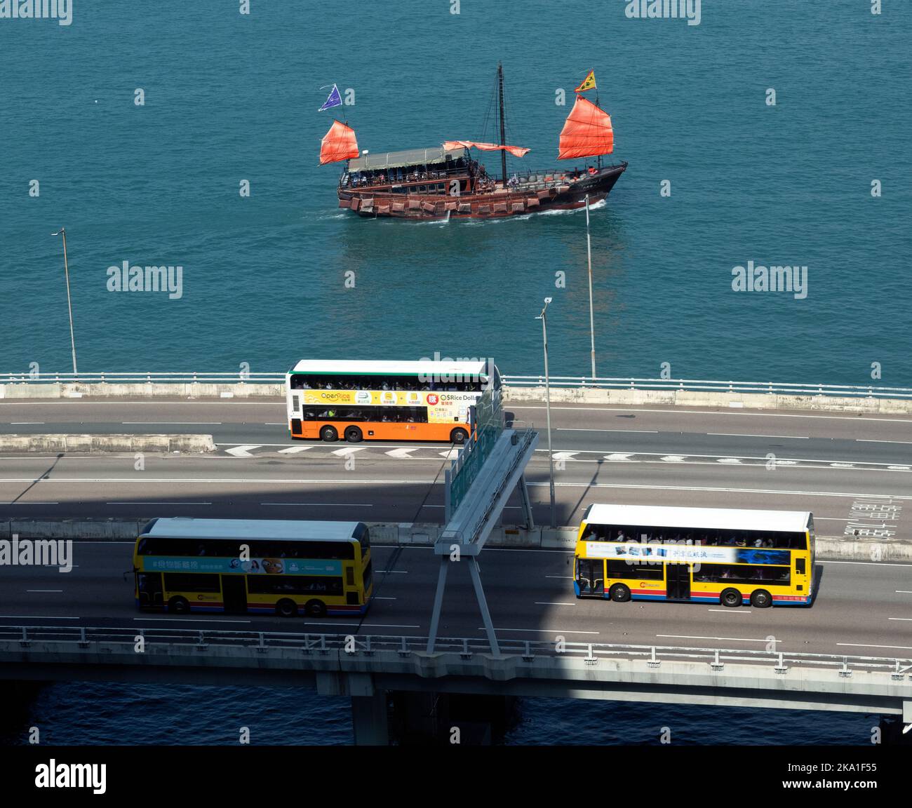 Autostrada sopraelevata e la famosa giunca turistica a vela rossa, Hong Kong, Cina. Foto Stock