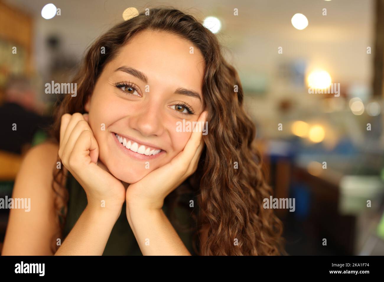 Ritratto di una donna felice con un sorriso perfetto in un ristorante che ti guarda Foto Stock