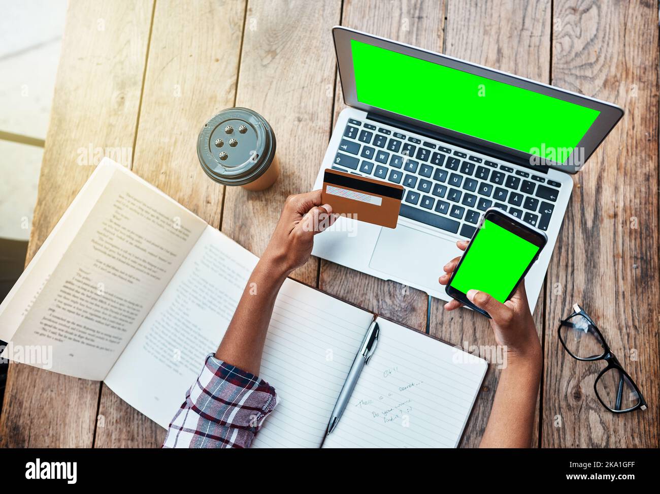 Controllare il suo prestito studente online. Ripresa ad angolo alto di una studentessa irriconoscibile che utilizza un computer portatile e una carta di credito all'esterno del campus. Foto Stock