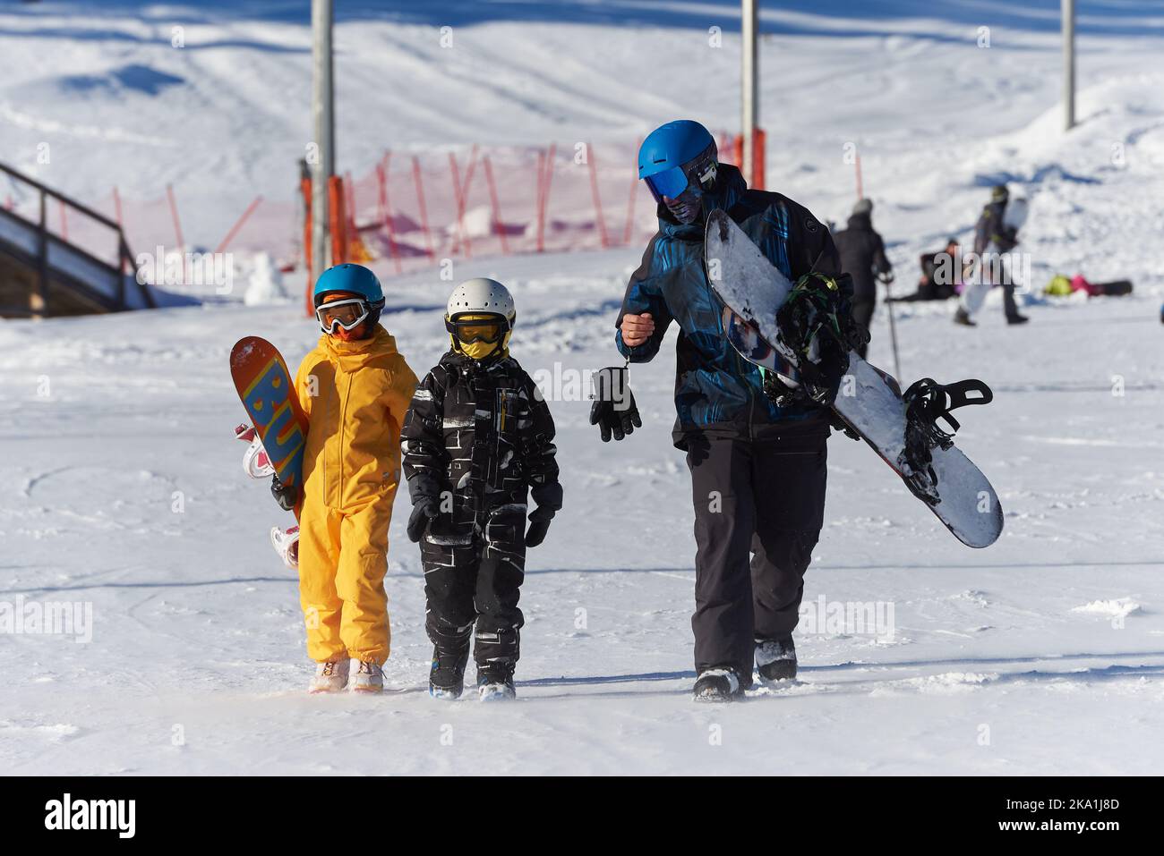 Padre insegna ai bambini lo snowboard nella stazione sciistica. Foto Stock