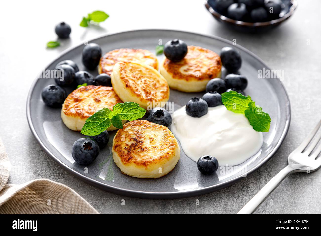 Frittelle di formaggio caserario con mirtillo fresco e yogurt per la prima colazione Foto Stock