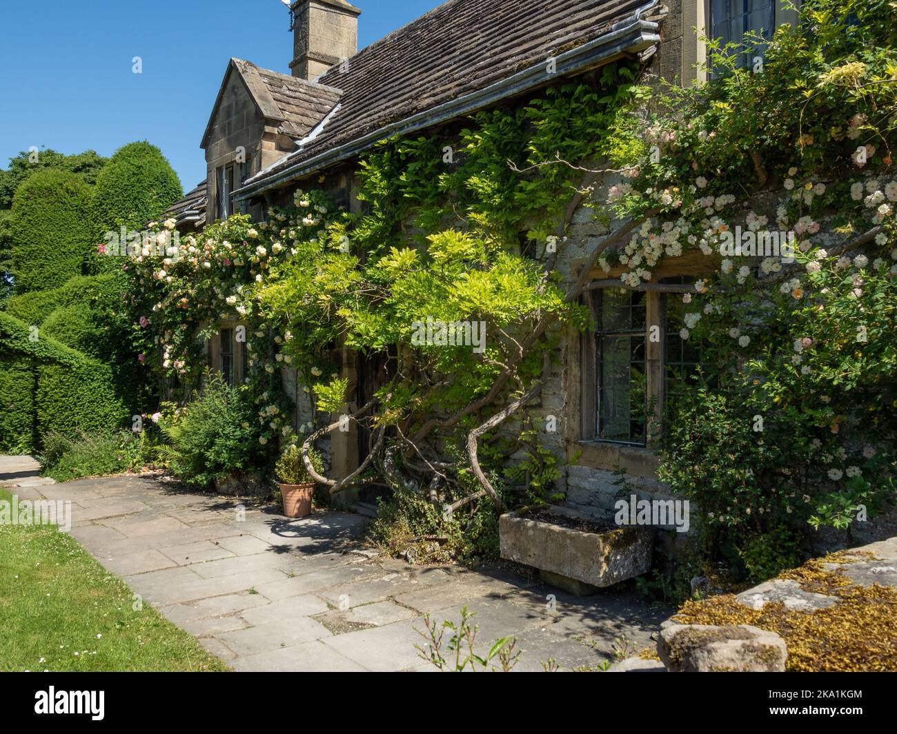 Attraente vecchio cottage con climber e rose all'ingresso di Haddon Hall, Derbyshire, Regno Unito Foto Stock