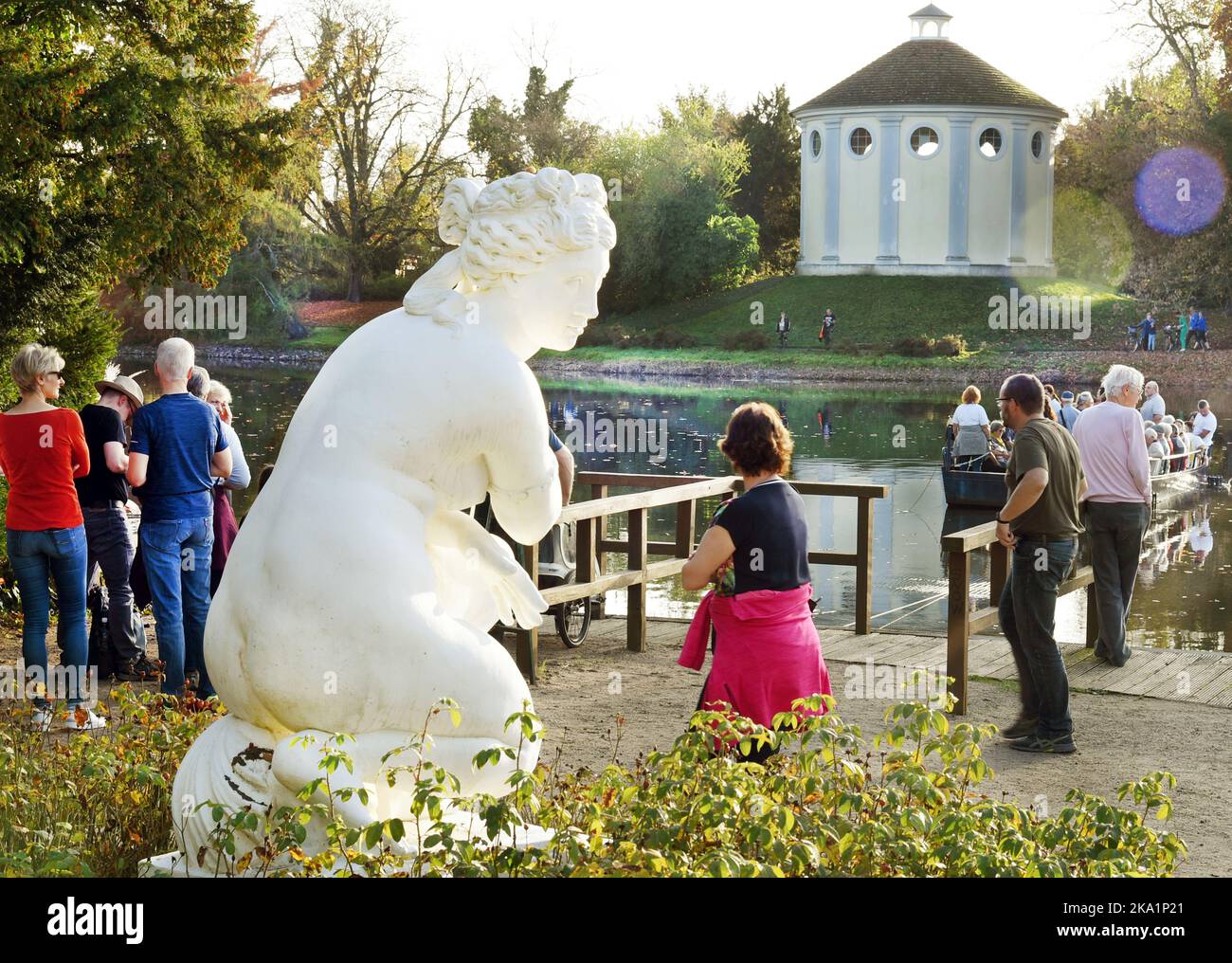 30 ottobre 2022, Sassonia-Anhalt, Wörlitz: Presso la stazione dei traghetti con la figura marmorea più grande della vita 'balneazione Venere', i visitatori attendono alle temperature estive nello storico Parco di Wörlitz per la traversata verso la sinagoga sul lato opposto del lago. Il parco è il pezzo centrale del Dessau-Wörlitz Garden Kingdom. I terreni sono patrimonio dell'umanità dell'UNESCO. Foto: Waltraud Gruditzsch/dpa-Zentralbild/dpa Foto Stock