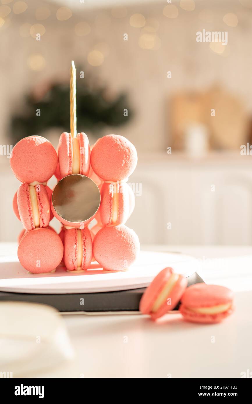 Torta con candele di macaron rosa su supporto rotondo sotto il sole Foto Stock