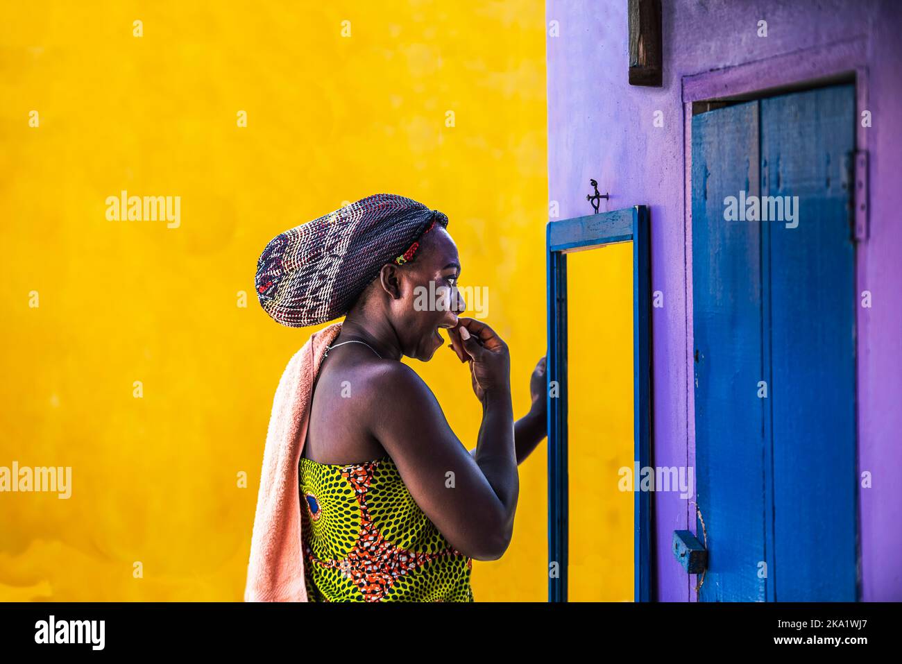 Donna africana con headdress sta all'aperto e ripulisce fuori del make-up nel piccolo villaggio di Keta Ghana Africa occidentale Foto Stock