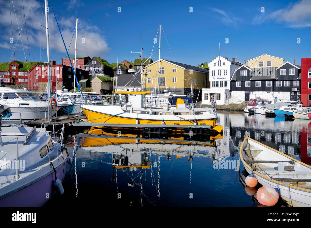 Riflessioni nella luce del mattino presto al porto di Torshavn, Isole Faroe, Danimarca. Include edifici con tetto in erba sintetica. Foto Stock