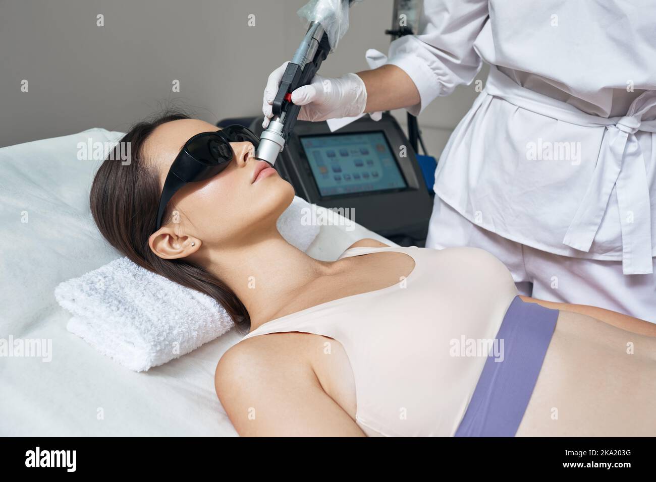 Rimozione dei peli del laser facciale. Bella donna durante la rimozione dei capelli laser e l'epilazione laser alla zona delle labbra sul viso Foto Stock