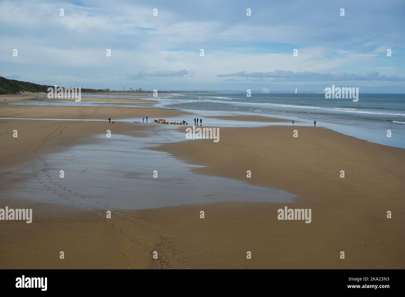 Vista in lontananza di un gruppo di praticanti surfisti sulla spiaggia di Saltburn by the Sea, North Yorkshire, UK Foto Stock