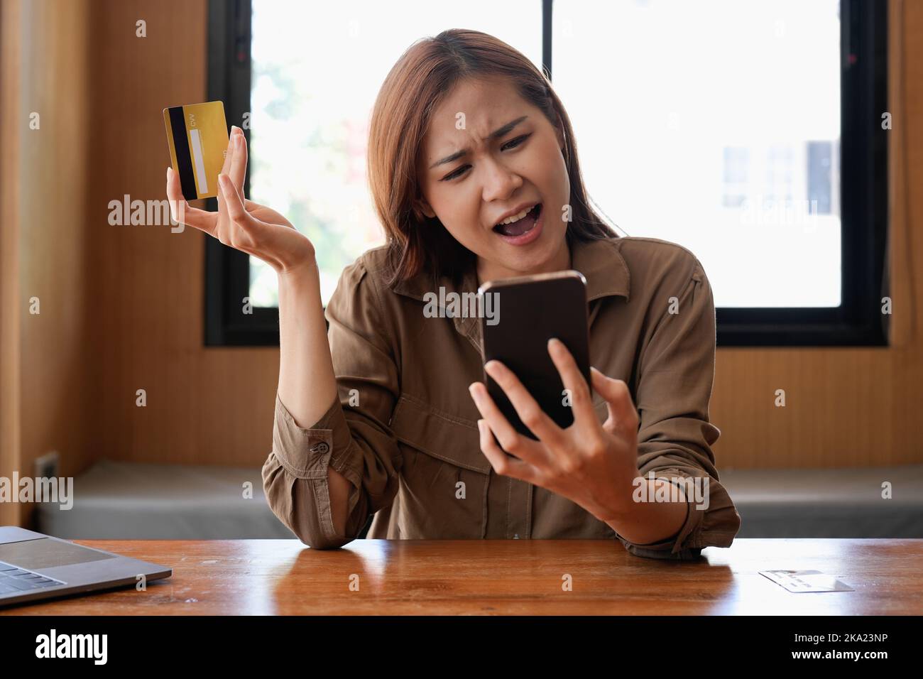 Infelice giovane acquirente asiatico femmina hanno problemi di acquisto online su Internet su smartphone con carta di credito. Donna frustrata arrabbiata confusa con il conto Foto Stock
