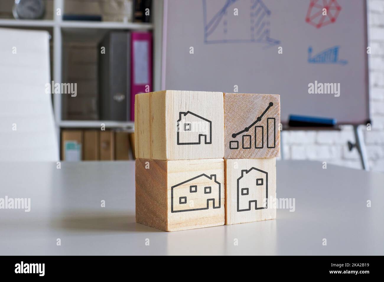 Concetto di investimento immobiliare. Cubi di legno con case e carta. Foto Stock