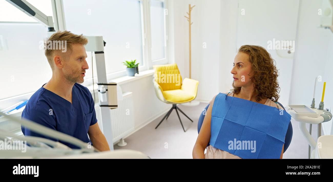 Dentista che ha consulto con il paziente nella sua ambulanza. Foto Stock