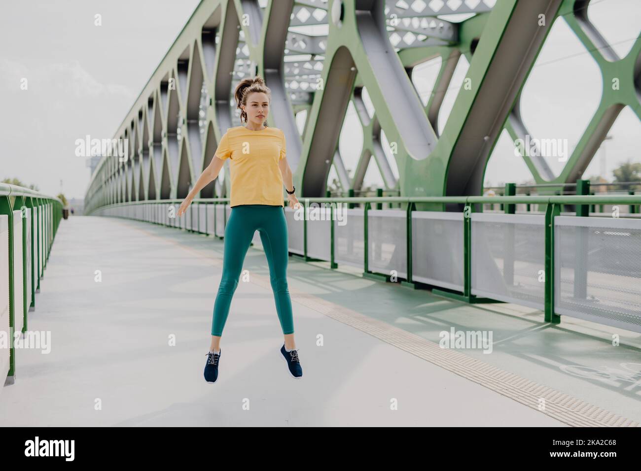 Giovane donna che fa stretching in città, preparandosi per la corsa, stile di vita sano e concetto di sport. Foto Stock