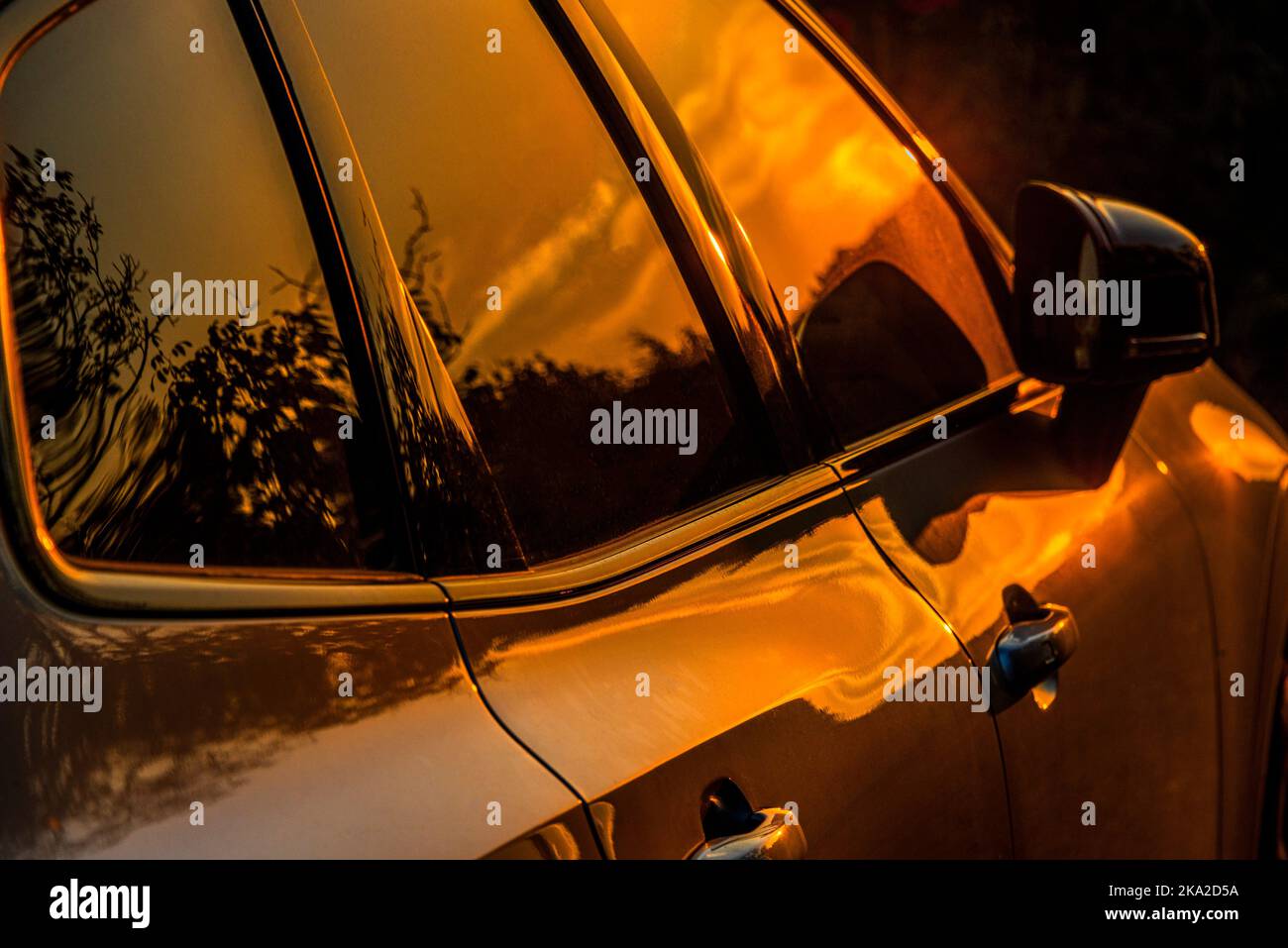 Le luci del tramonto sulla superficie metallica e sui finestrini di una moderna Volvo. Foto Stock