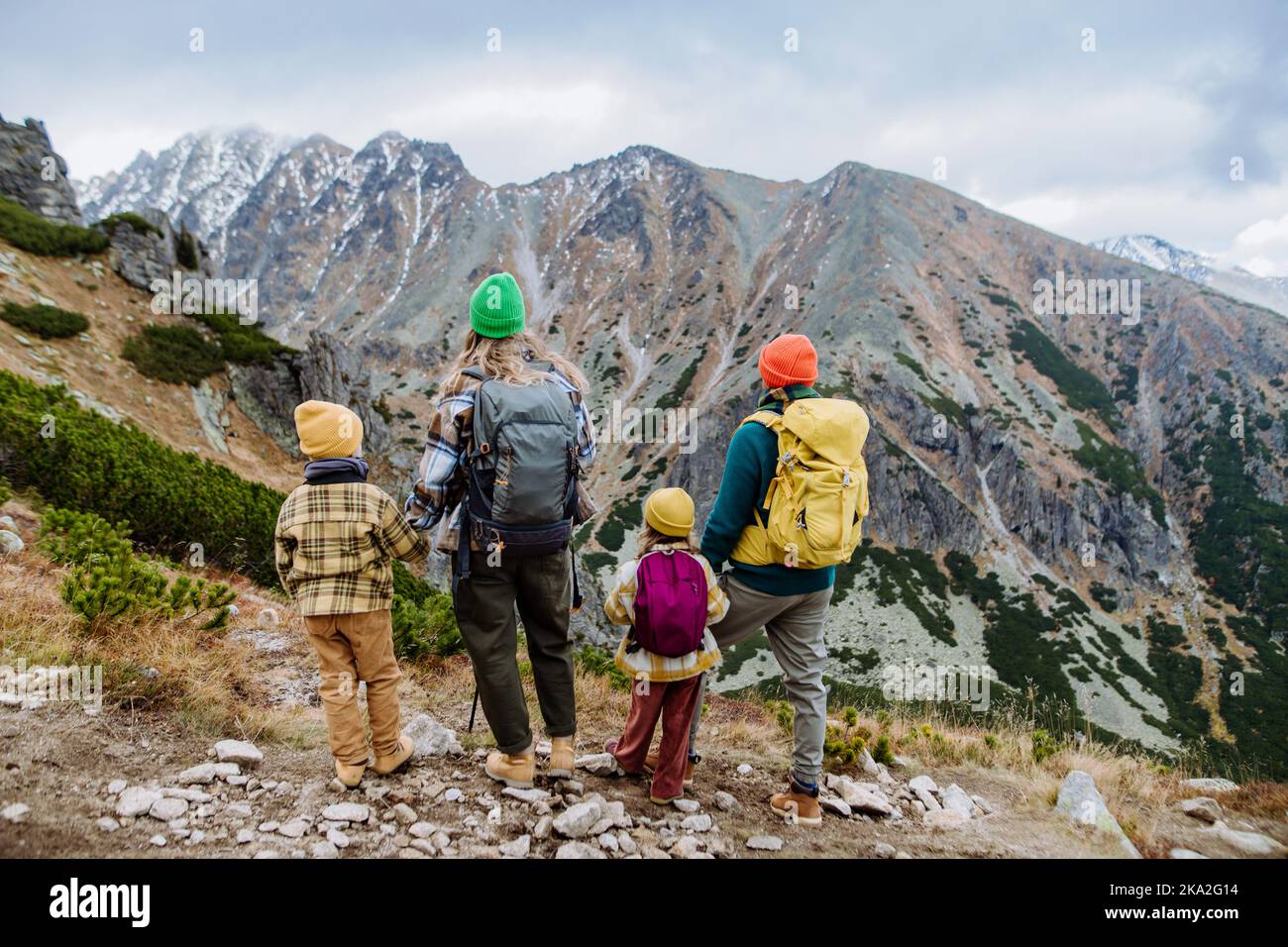 Vista posteriore della famiglia con i bambini piccoli sulle montagne autunnali. Concetto di stile di vita sano. Foto Stock