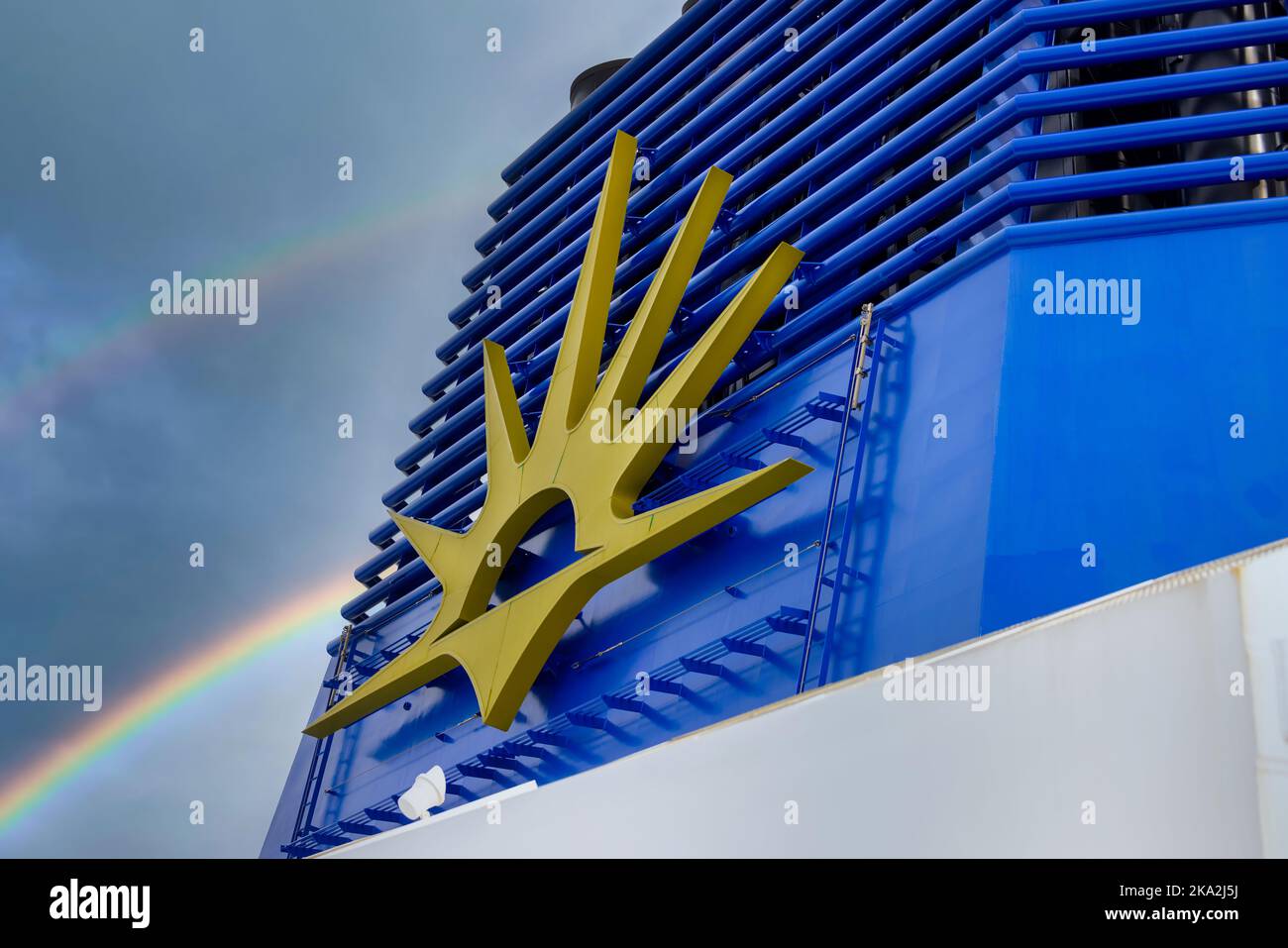 Southampton, Inghilterra, P&o Ferry, nave da crociera di lusso Iona ormeggiata nel porto con arcobaleno dietro lo stack del camino e simbolo dorato dell'alba con logo P and O. Foto Stock