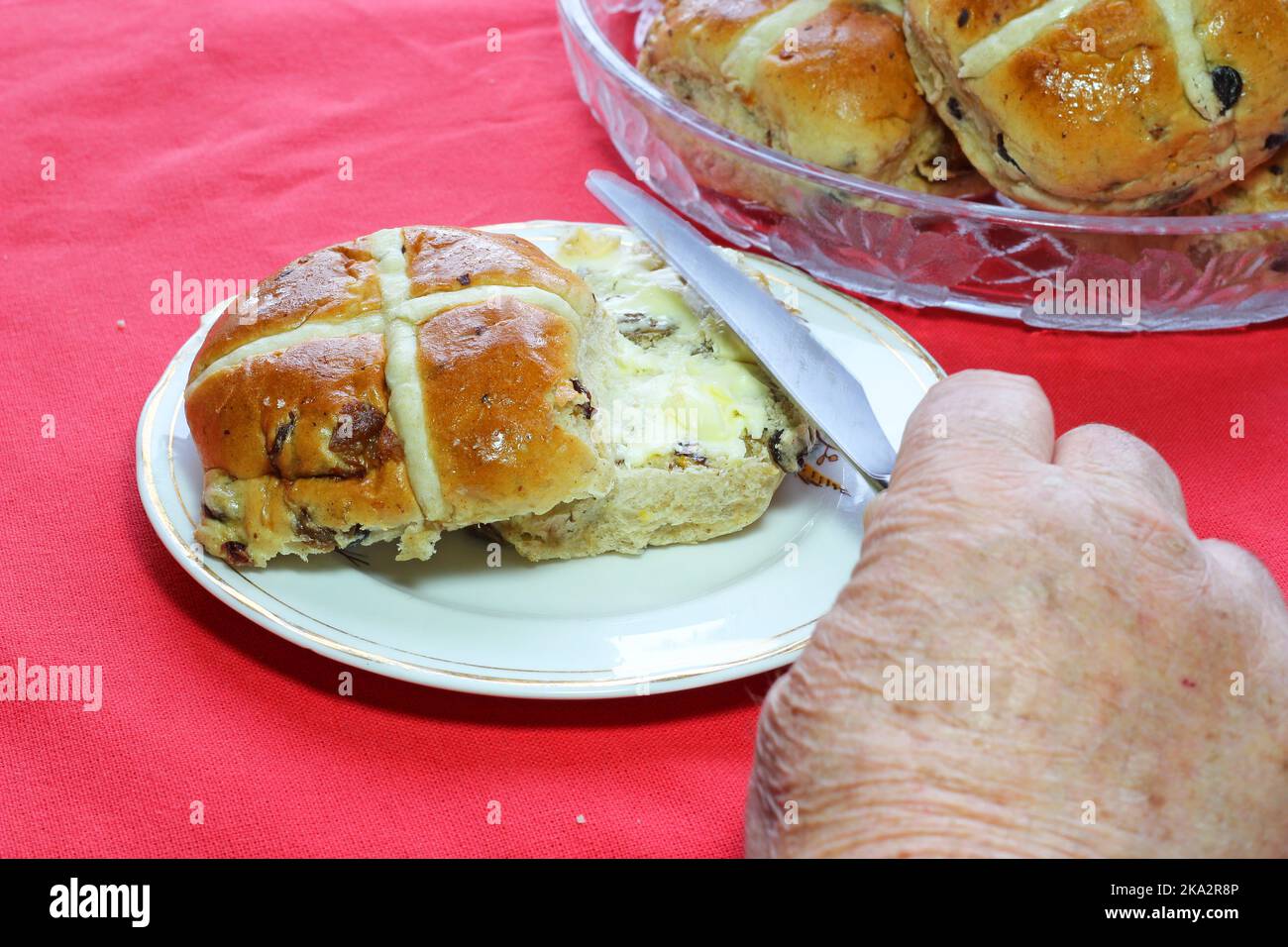 Panini croci caldi a Pasqua con burro. Uva di Corinto e frutta secca mista nei panini. Foto Stock
