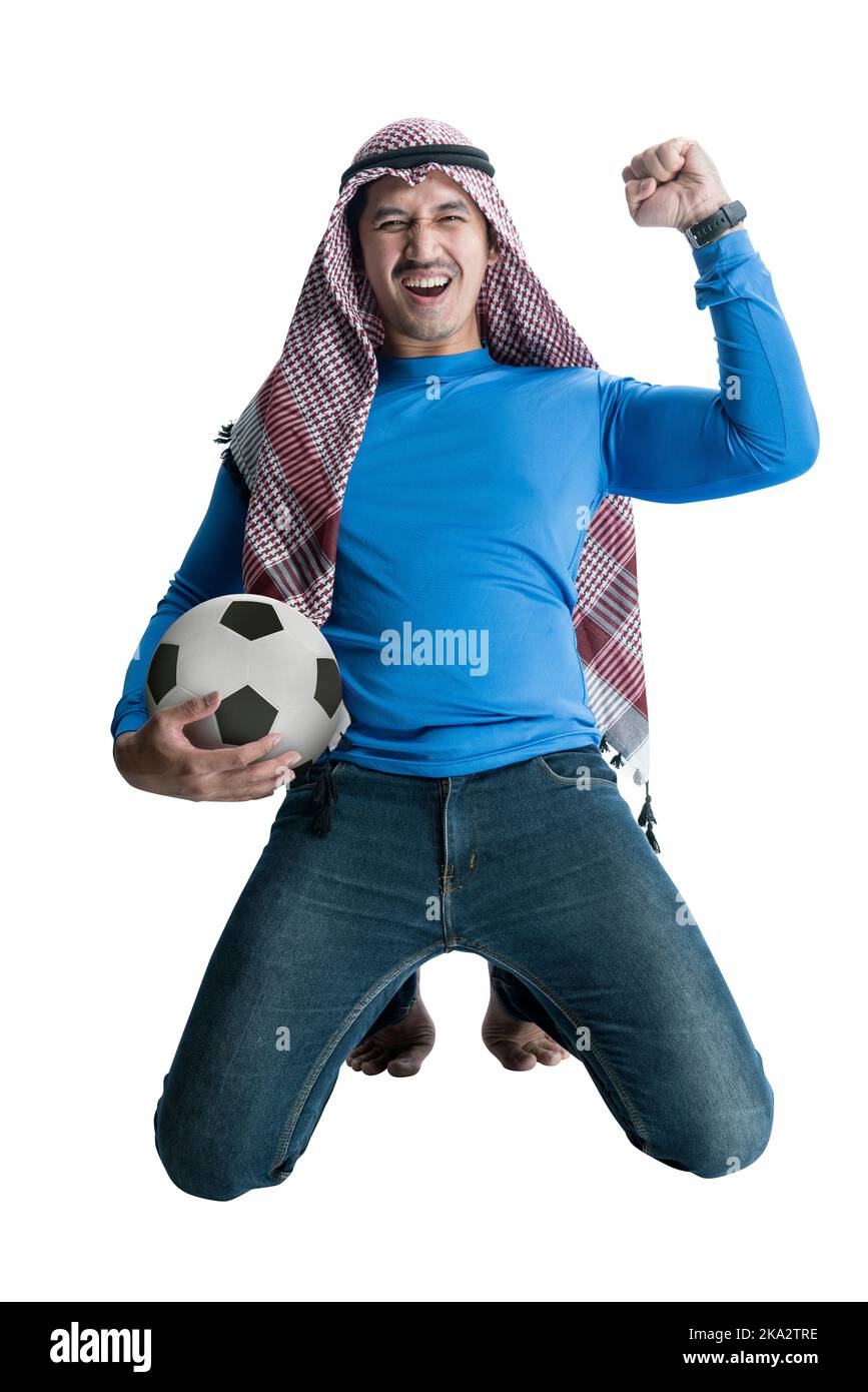 Uomo asiatico con keffiyeh che tiene la palla mentre celebra la vittoria con un'espressione eccitata isolato su sfondo bianco Foto Stock