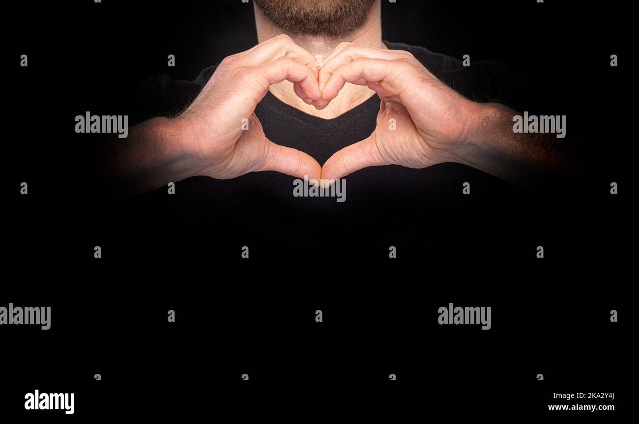 Le mani maschili mostrano un simbolo del cuore. Foto Stock