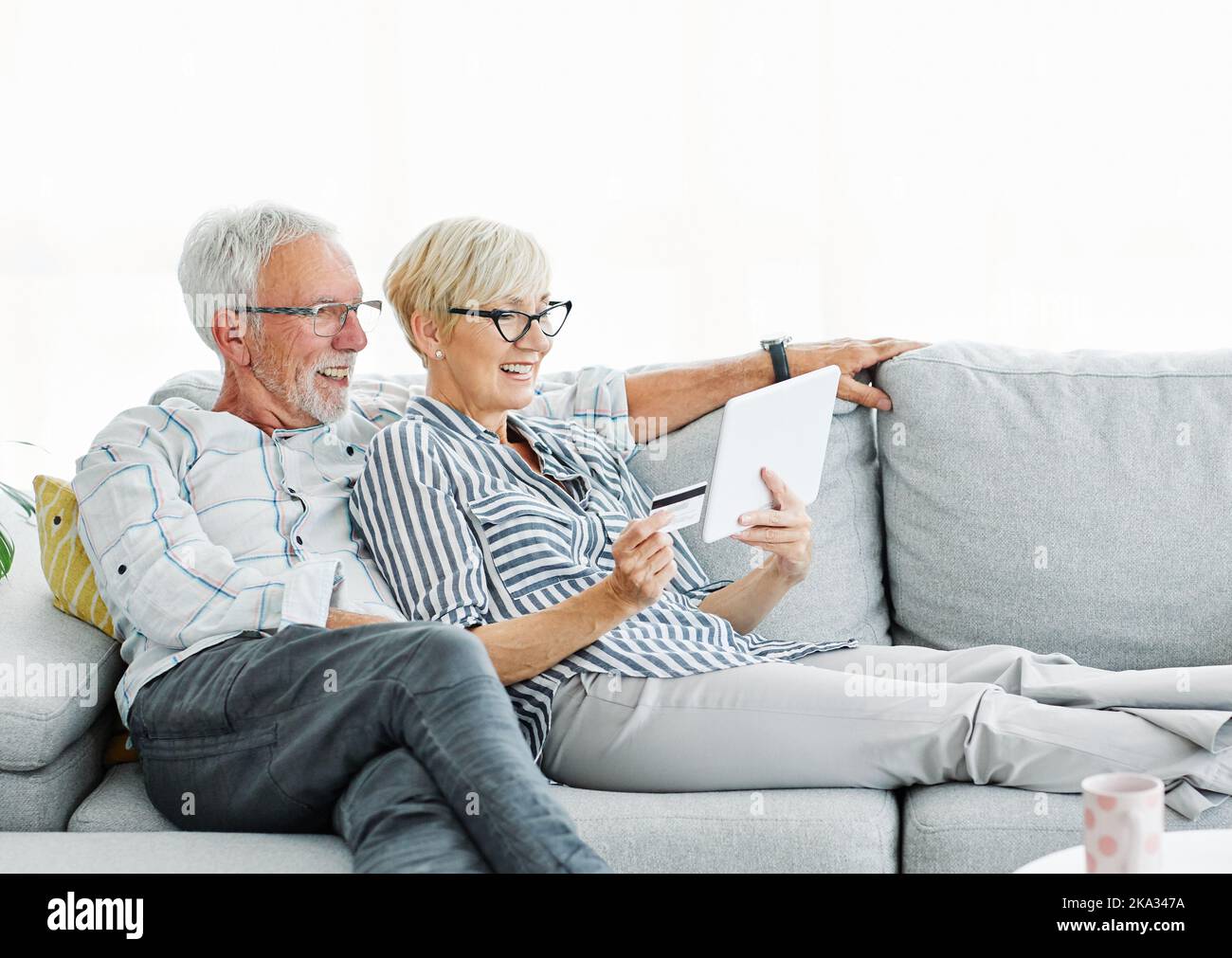 senior coppia felice tablet computer amore insieme tecnologia internet pensionamento online uomo donna anziano Foto Stock