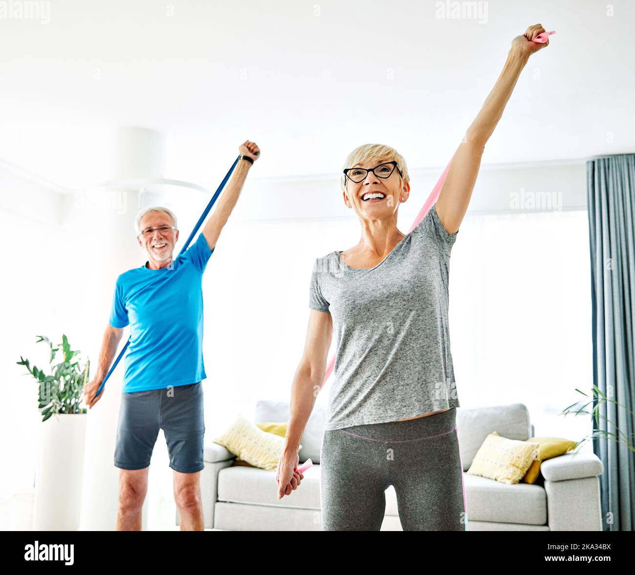 senior stretching esercizio donna allenamento lifestyle sport fitness casa palestra sana esercizio forma uomo coppia squadra resistenza band Foto Stock