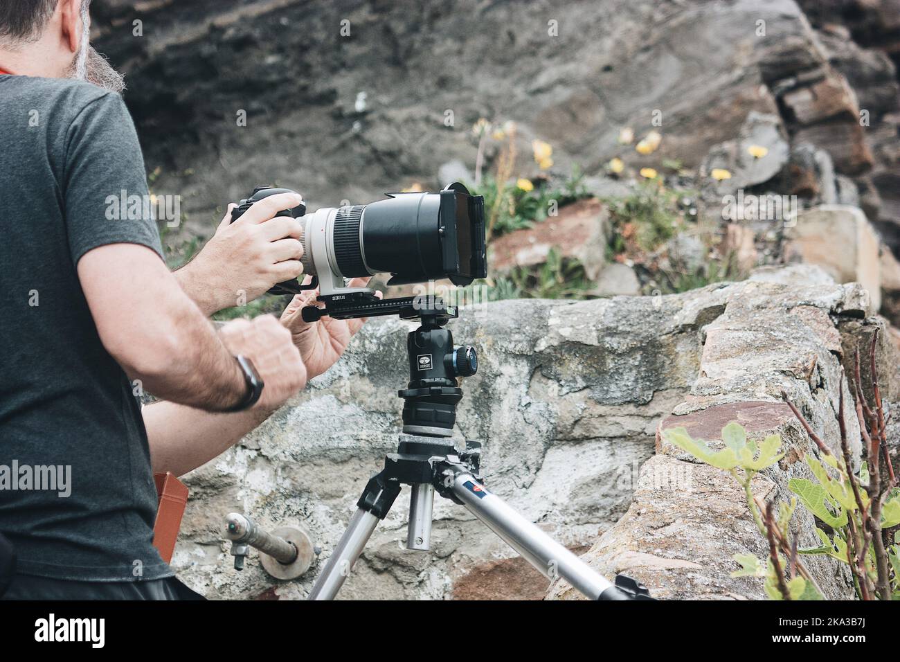 Un primo piano i fotografi hanno messo la fotocamera su un cavalletto su una pietra Foto Stock