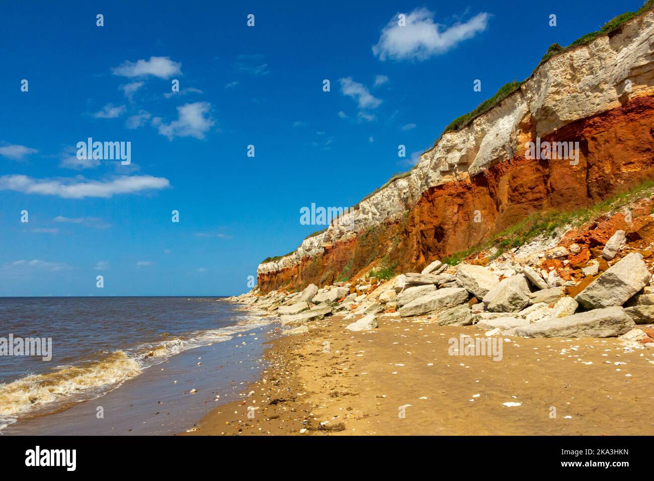 Vista della pietra calcarea Cretacea rossa stratificata pietra calcarea e scogliere bianche di gesso sulla spiaggia di Old Hunstanton, nella parte occidentale del Norfolk Inghilterra UK. Foto Stock