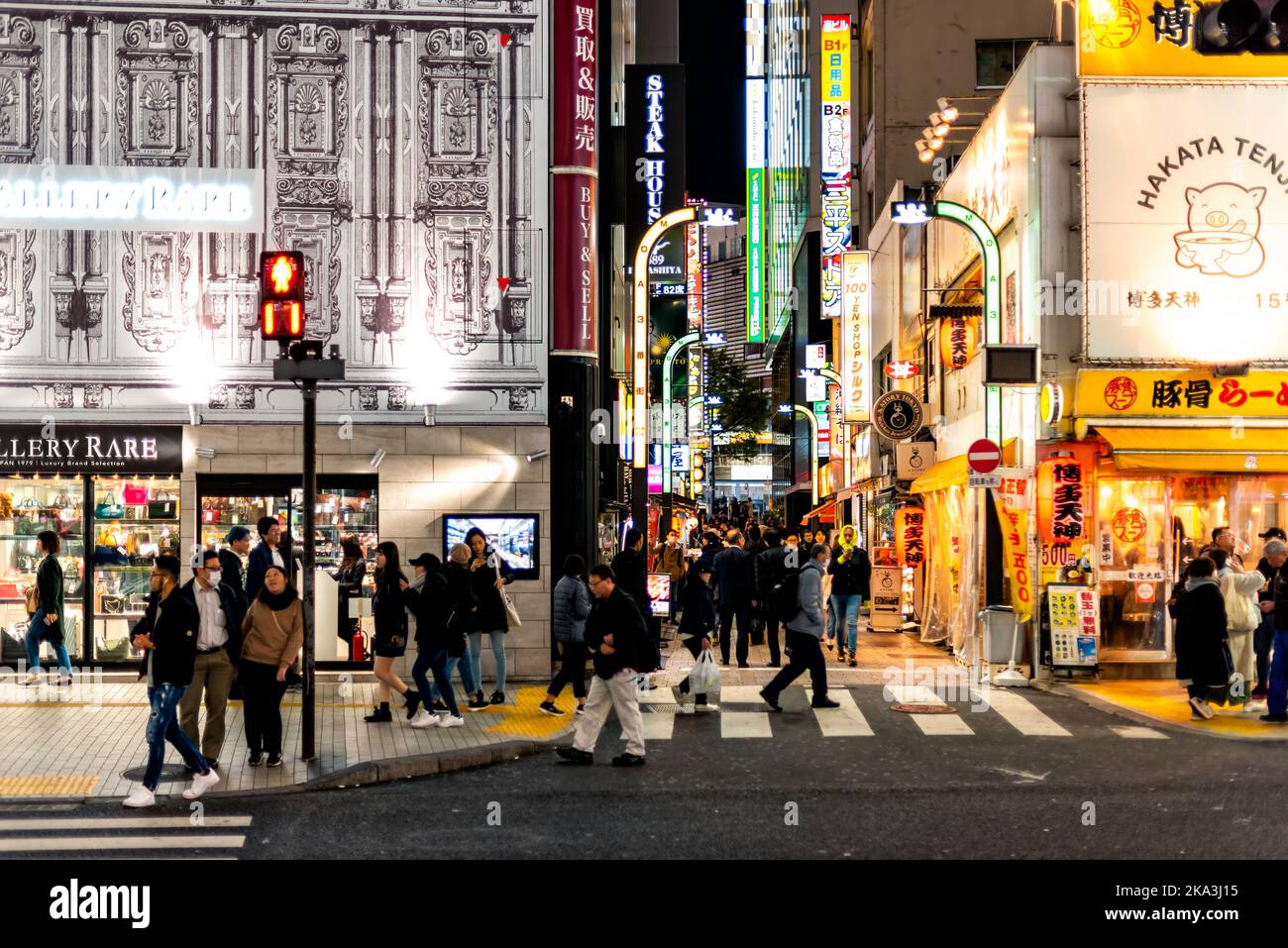 Shinjuku, Giappone - 3 aprile 2019: Persone a piedi sul famoso quartiere a luci rosse dello shopping Kabukicho vicolo strada nel centro della città con molti al neon Bright li Foto Stock