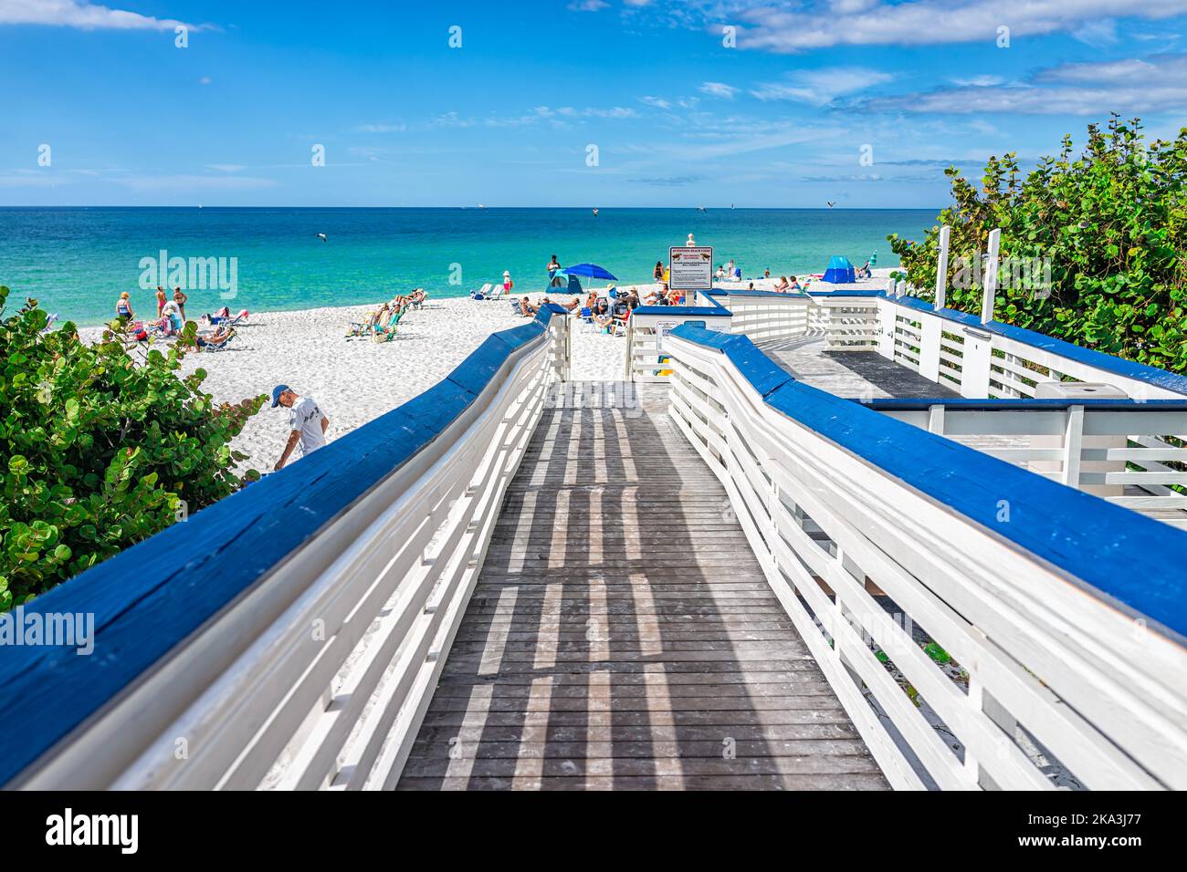 Napoli, USA - 4 dicembre 2021: Rampa al parco Clam pass spiaggia di contea di Collier, Florida con persone che prendono il sole sotto gli ombrelloni su sedie con beautifu Foto Stock