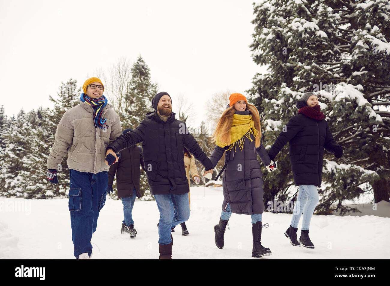 Amici felici e diversi rilassarsi all'aperto durante le vacanze invernali Foto Stock