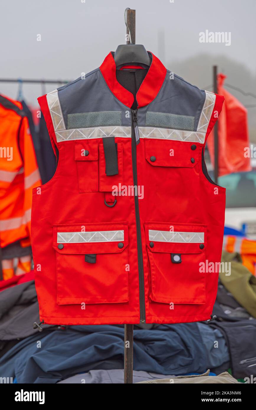 Giubbino di sicurezza rosso brillante con cinghie riflettenti, attrezzatura da lavoro Foto Stock