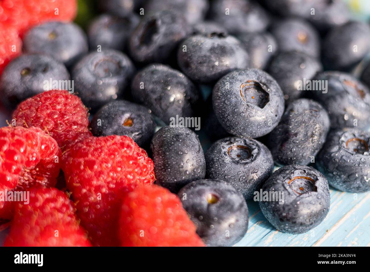 Bacche su sfondo di legno. Estate o primavera bacche biologiche. Fragole, lamponi, mirtilli. Agricoltura, giardinaggio, concetto di raccolta Foto Stock