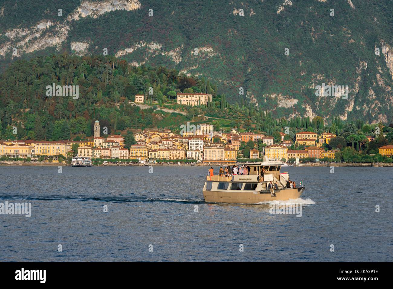 Panoramica Italia, vista in estate di un piccolo traghetto che attraversa il lago di Como e che porta i turisti da Bellagio a Tremezzo, Lombardia, Italia Foto Stock