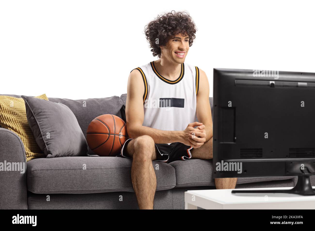 Giocatore di basket seduto su un divano e guardare la tv isolato su sfondo bianco Foto Stock