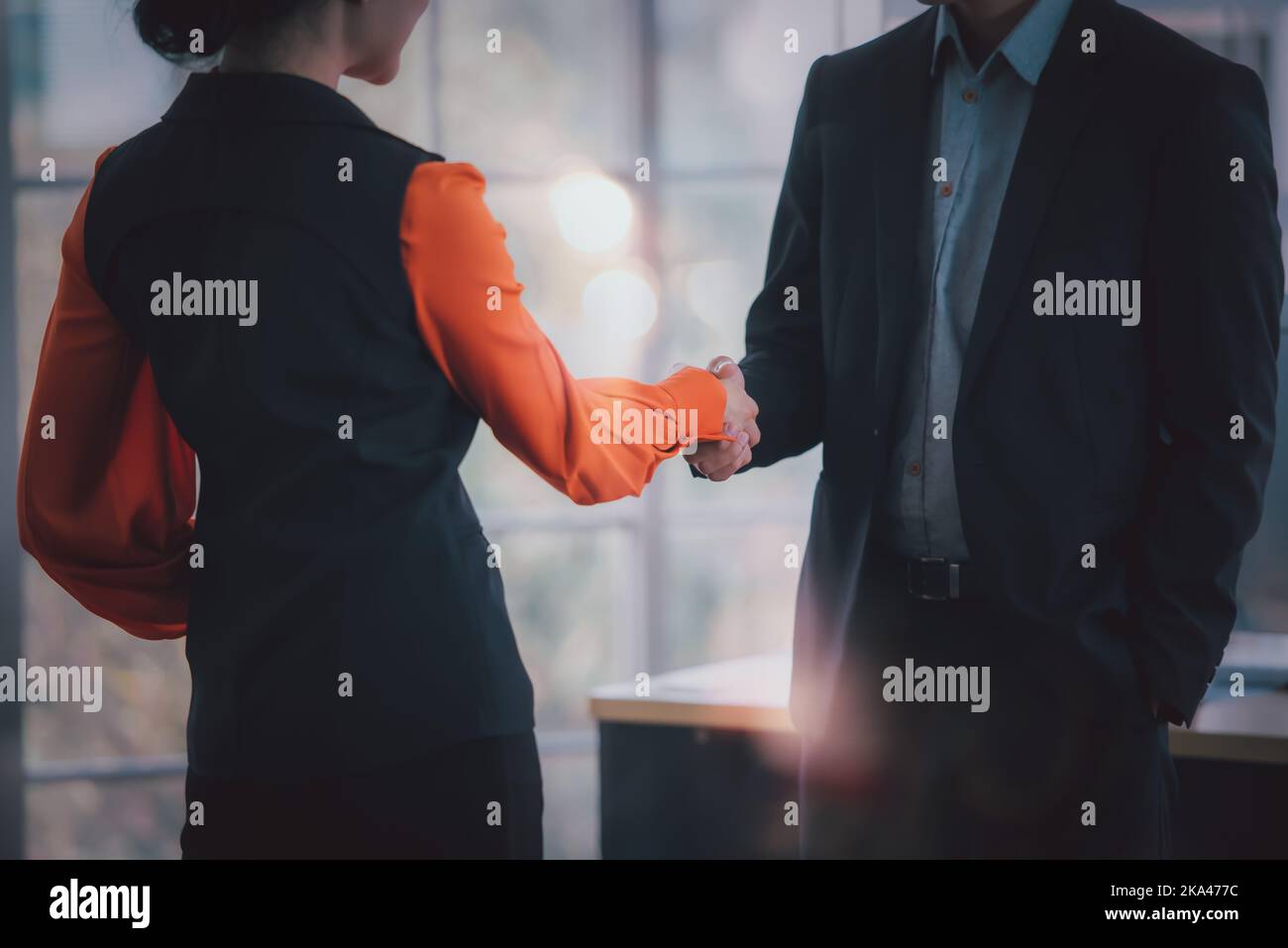 Gli uomini d'affari scuotono le mani insieme, salutano e vengono bene, i colleghi positivi felici nello spazio di lavoro, sorridendo il team di affari che parla avendo enjo divertente Foto Stock