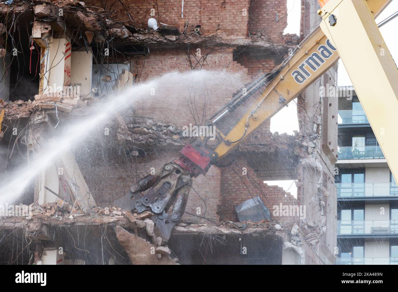 La gru Armac Cat demolisce l'edificio dell'asse con spruzzi d'acqua per ridurre la polvere., Birmingham, Warwickshire, West midlands Foto Stock