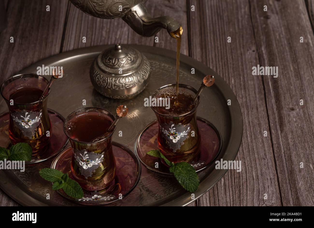 Serve tè moresco caldo su un vassoio con bicchieri e caraffa su un tavolo di legno Foto Stock