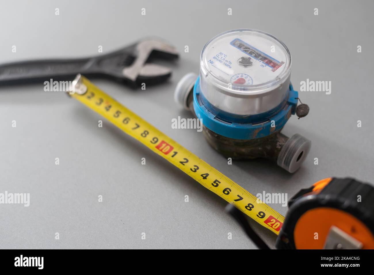 contatore dell'acqua su sfondo chiaro. Figure per misurare acqua in metri cubici. Forma rotonda della custodia. Foto Stock